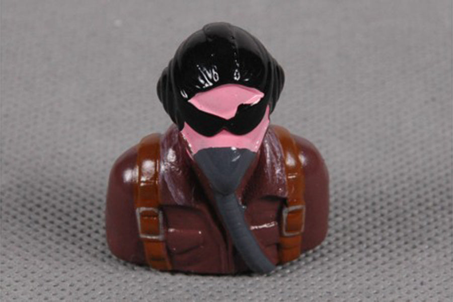 Character figurine with a pink mask and goggles in a brown jacket